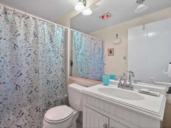 a bathroom with a sink a toilet and shower curtain