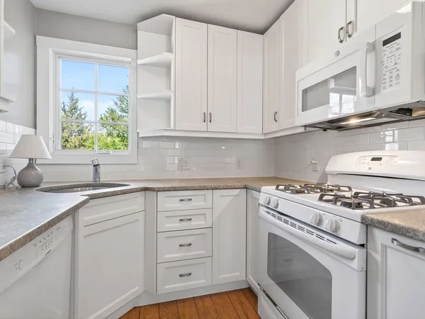 a kitchen with cabinets appliances and a window