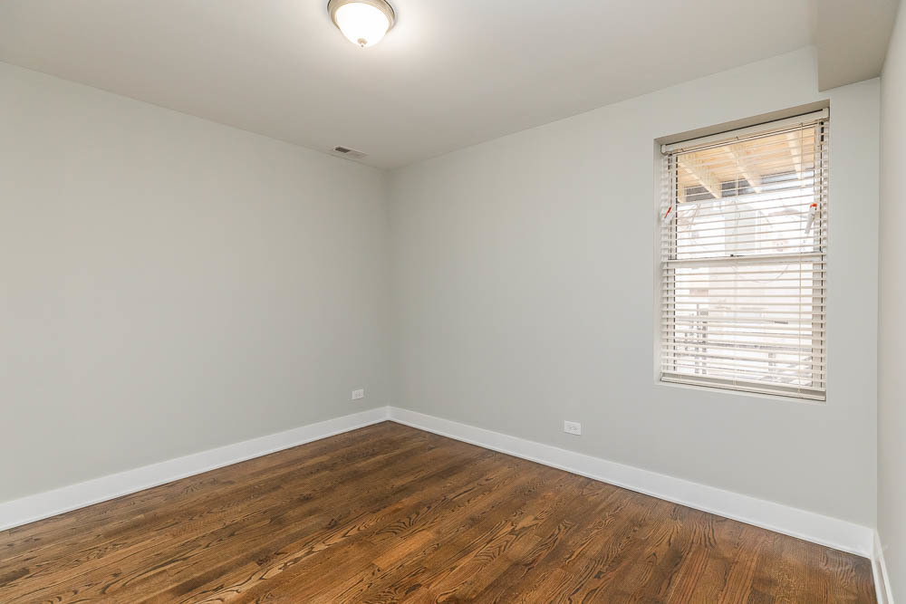 2109 West 18th Place Chicago, IL 60608 - Photo 15 of 63 an empty room with wooden floor and windows
