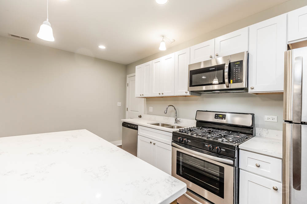 2109 West 18th Place Chicago, IL 60608 - Photo 48 of 63 a kitchen with stainless steel appliances a stove microwave and sink