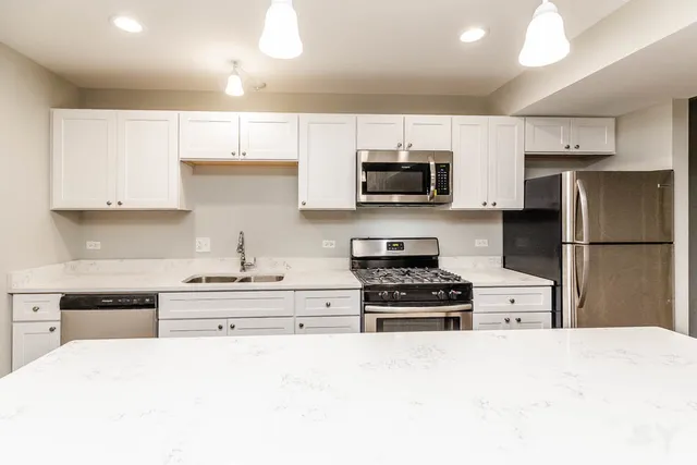 a kitchen with stainless steel appliances granite countertop a stove and a microwave