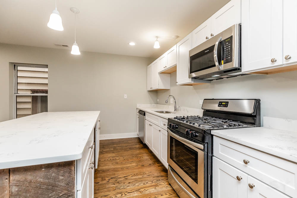 2109 West 18th Place Chicago, IL 60608 - Photo 9 of 63 a kitchen with stainless steel appliances granite countertop a stove top oven microwave and cabinets