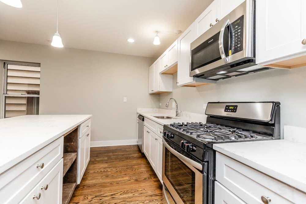 2109 West 18th Place Chicago, IL 60608 - Photo 10 of 63 a kitchen with stainless steel appliances granite countertop a stove and a microwave