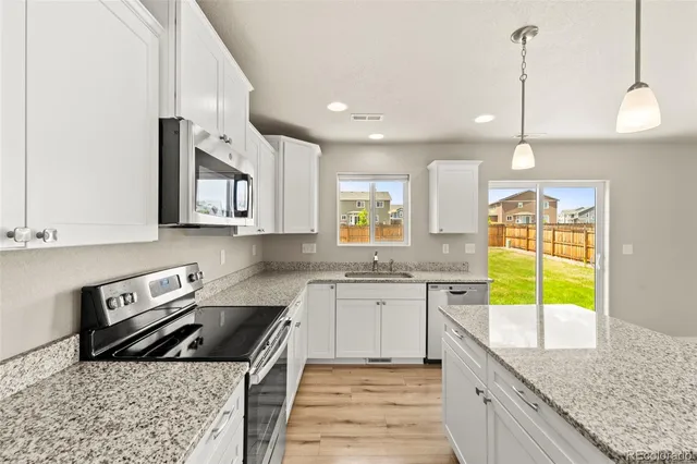 a kitchen with a sink a counter top space cabinets and stainless steel appliances
