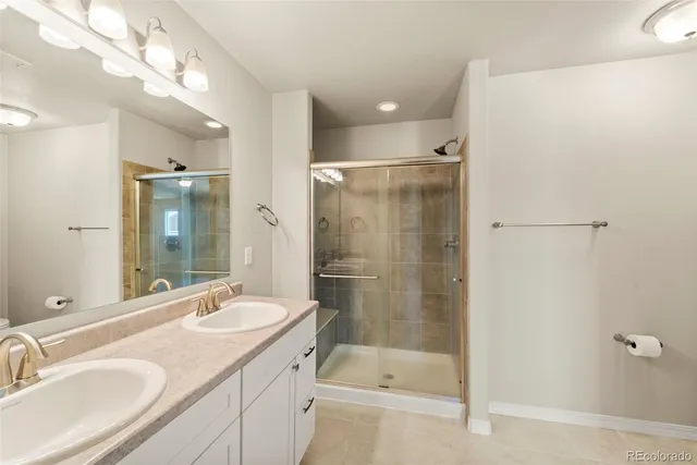 a bathroom with a shower sink vanity granite and shower