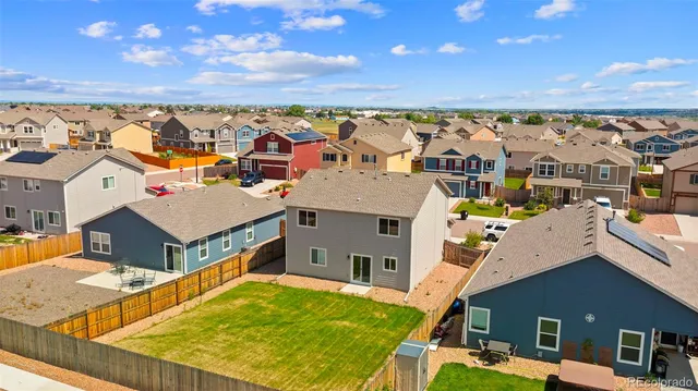an aerial view of residential houses with outdoor space and ocean