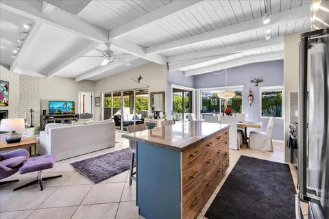 a living room with patio furniture and a potted plant
