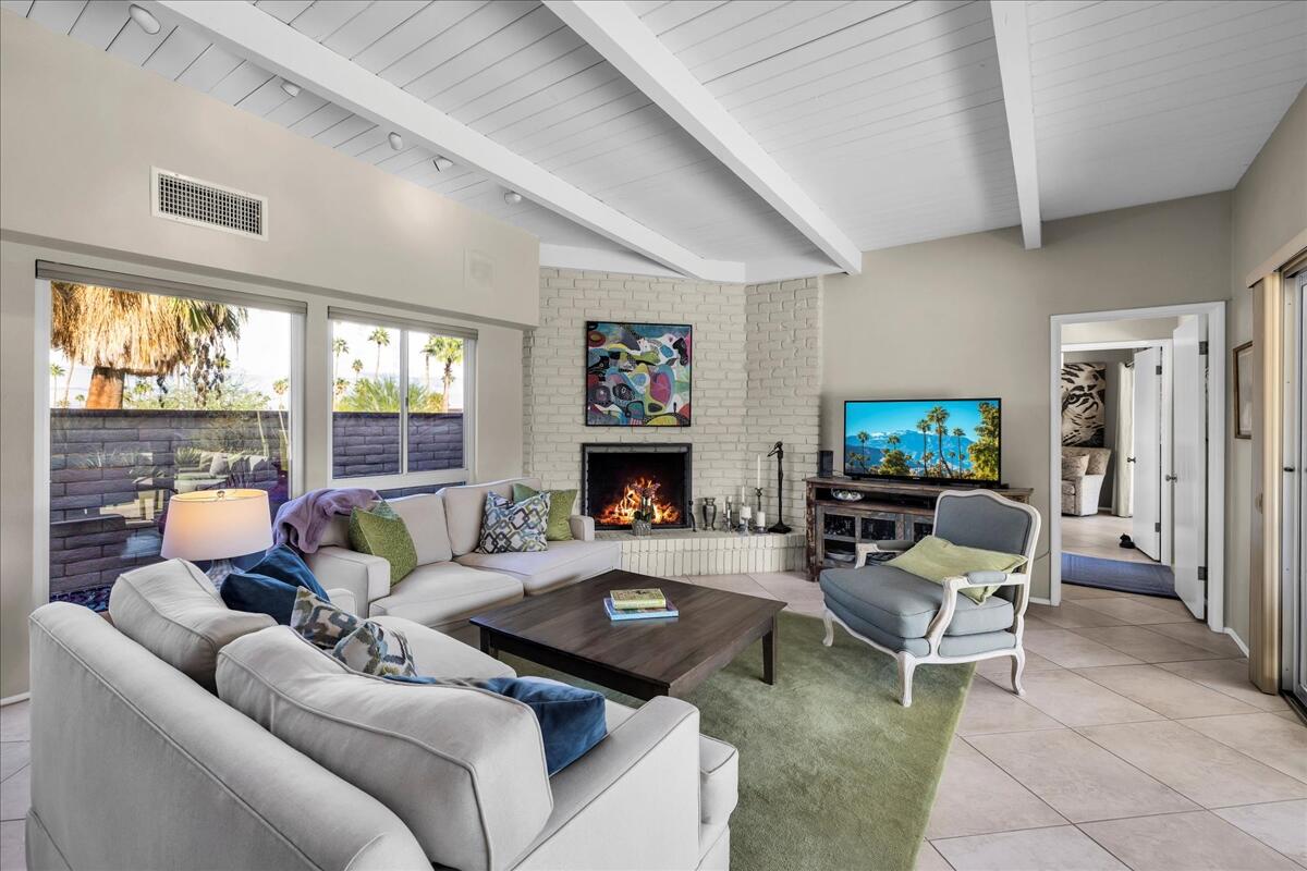 73501 Little Bend Trail Palm Desert, CA 92260 - Photo 10 of 57 a living room with furniture a fireplace and a large window