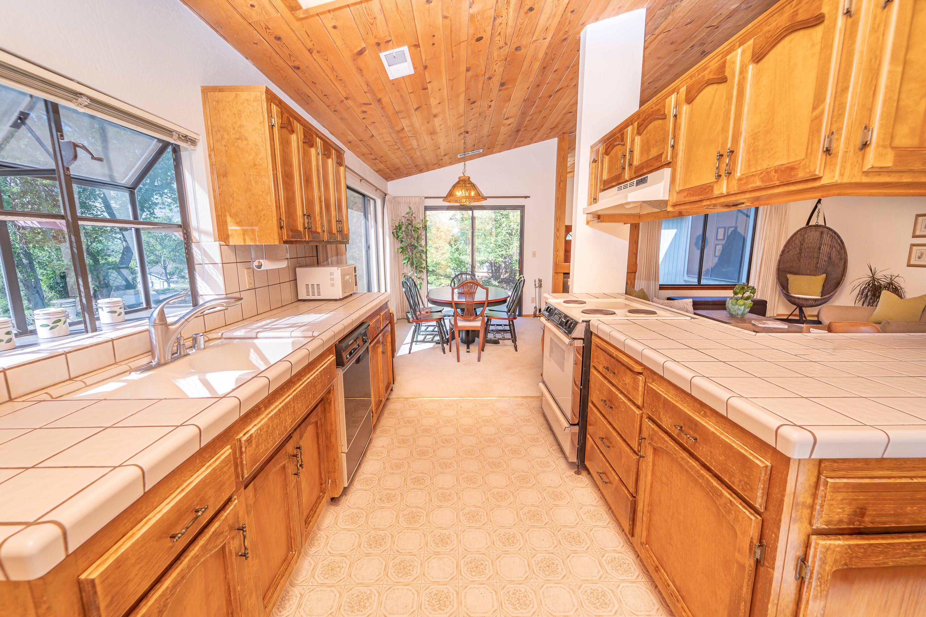 40962 Oak Ridge Drive Three Rivers, CA 93271 - Photo 14 of 36 a view of a kitchen with kitchen island a large window a sink and dining table view