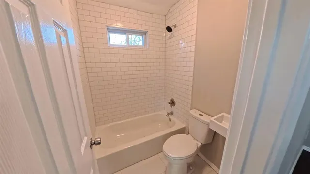 a bathroom with a granite countertop toilet and a sink
