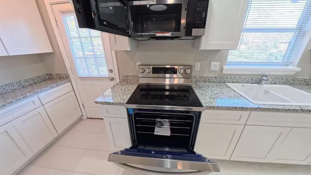 a kitchen with granite countertop a stove and a sink