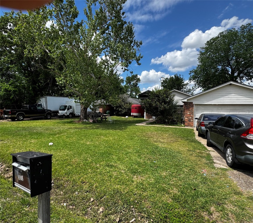 8910 Carousel Lane Houston, TX 77080 - Photo 2 of 7 a view of a yard with cars parked in front of yellow house