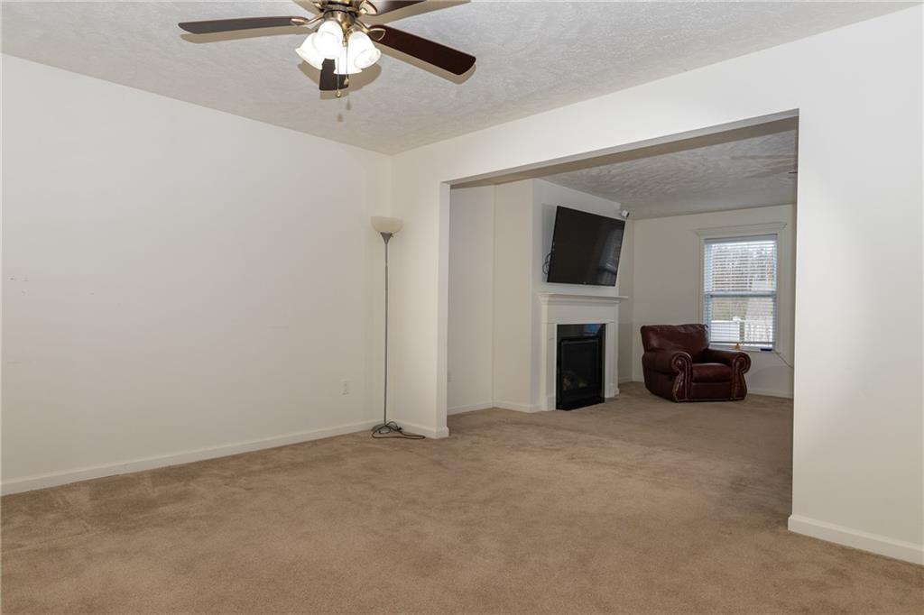 100 Willow Drive Natrona Heights, PA 15065 - Photo 11 of 20 a view of a livingroom with a fireplace a ceiling fan a kitchen and a window