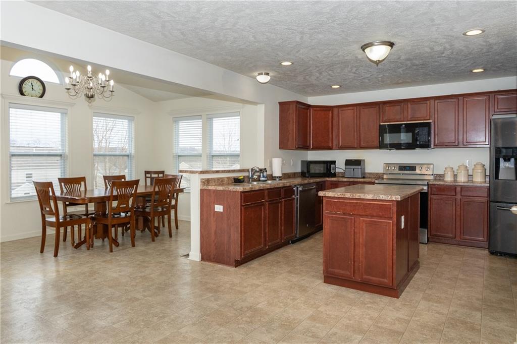 100 Willow Drive Natrona Heights, PA 15065 - Photo 7 of 20 a kitchen with a sink a microwave and chairs