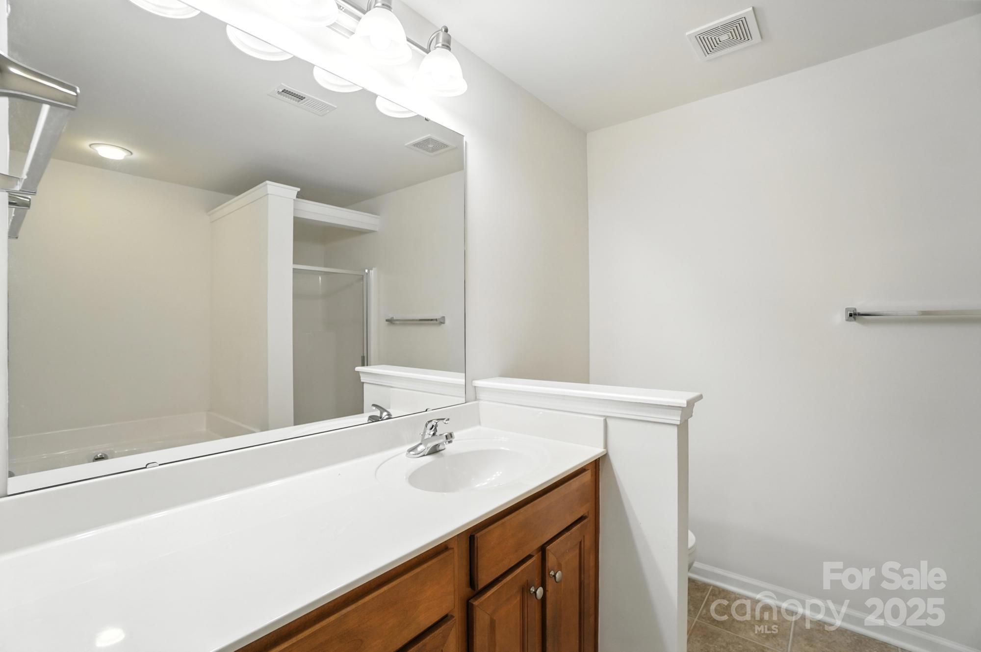 13116 Erwin Road Charlotte, NC 28273 - Photo 19 of 27 a bathroom with a sink vanity and a mirror