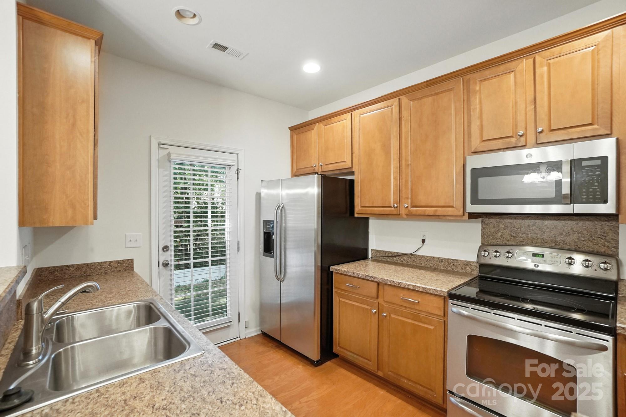 13116 Erwin Road Charlotte, NC 28273 - Photo 10 of 27 a kitchen with stainless steel appliances granite countertop a stove a sink and a microwave