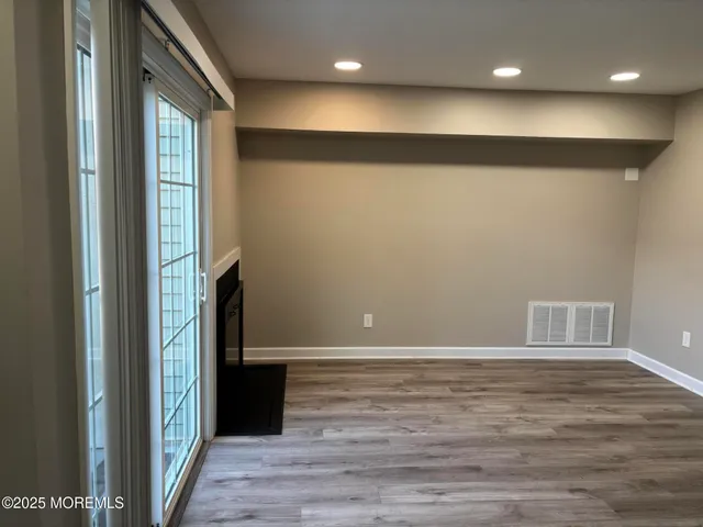 a view of an empty room with wooden floor and staircase