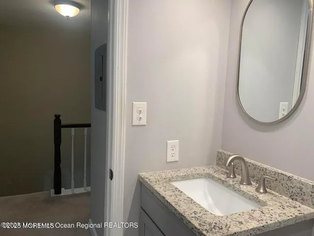 a bathroom with a granite countertop sink a mirror and a vanity