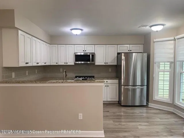 a kitchen with stainless steel appliances granite countertop a refrigerator stove a sink and a granite counter tops