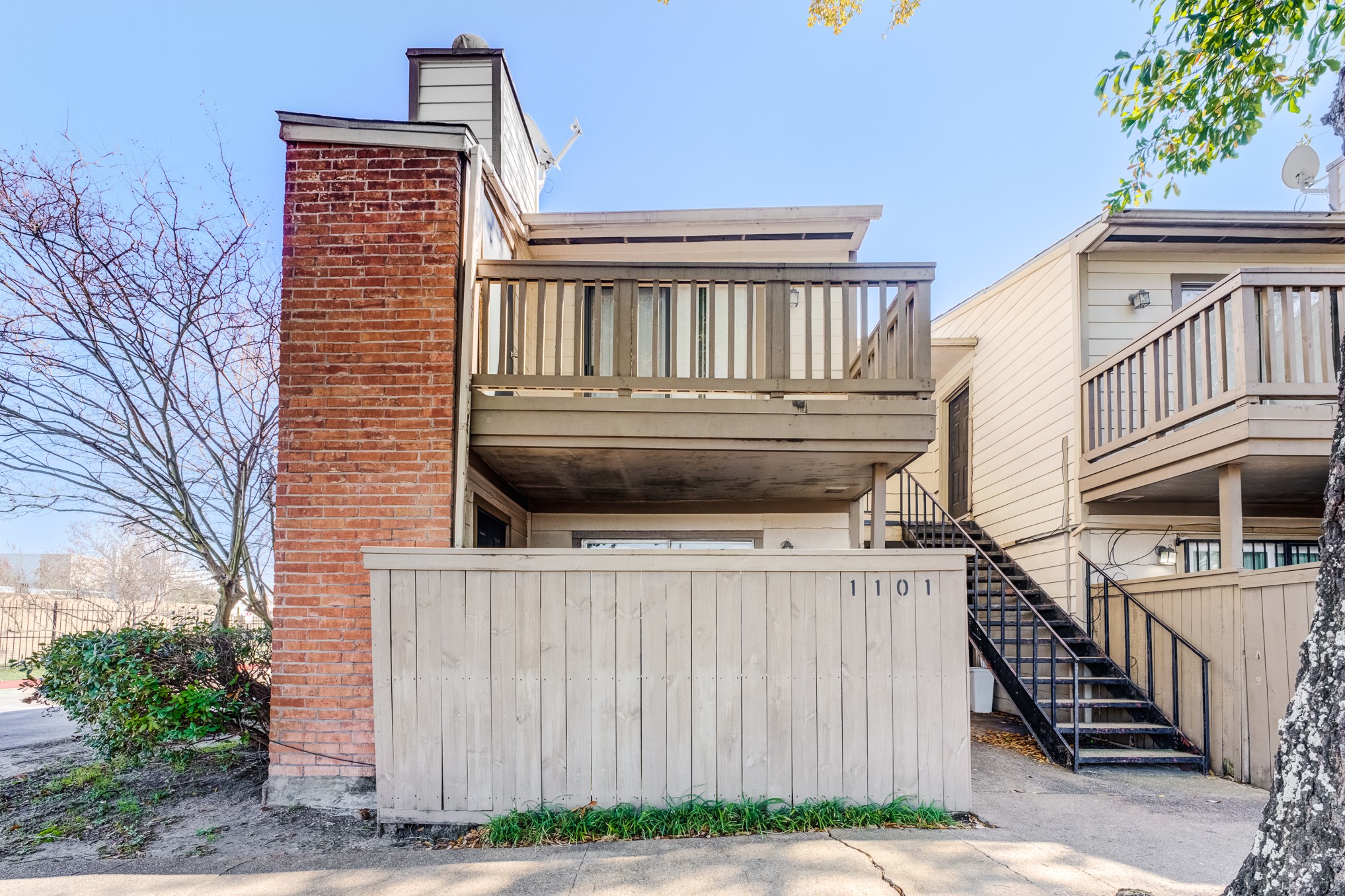 a view of a house with a wooden fence