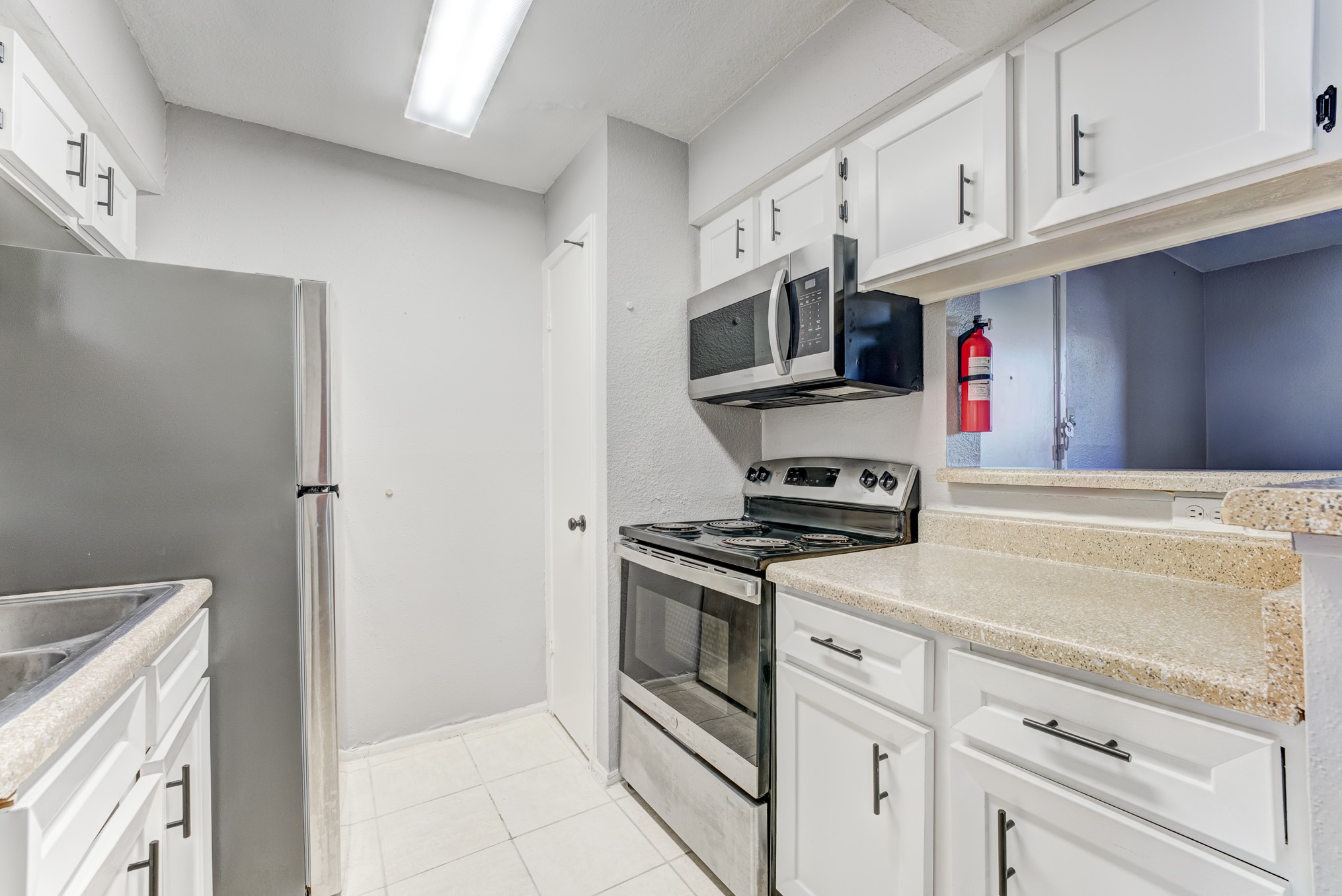 6001 Reims Road, Unit 1101 Houston, TX 77036 - Photo 19 of 35 a kitchen with stainless steel appliances granite countertop a stove and a refrigerator