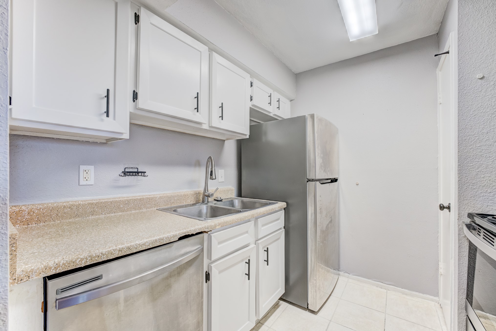 6001 Reims Road, Unit 1101 Houston, TX 77036 - Photo 21 of 35 a kitchen with stainless steel appliances granite countertop a sink and refrigerator