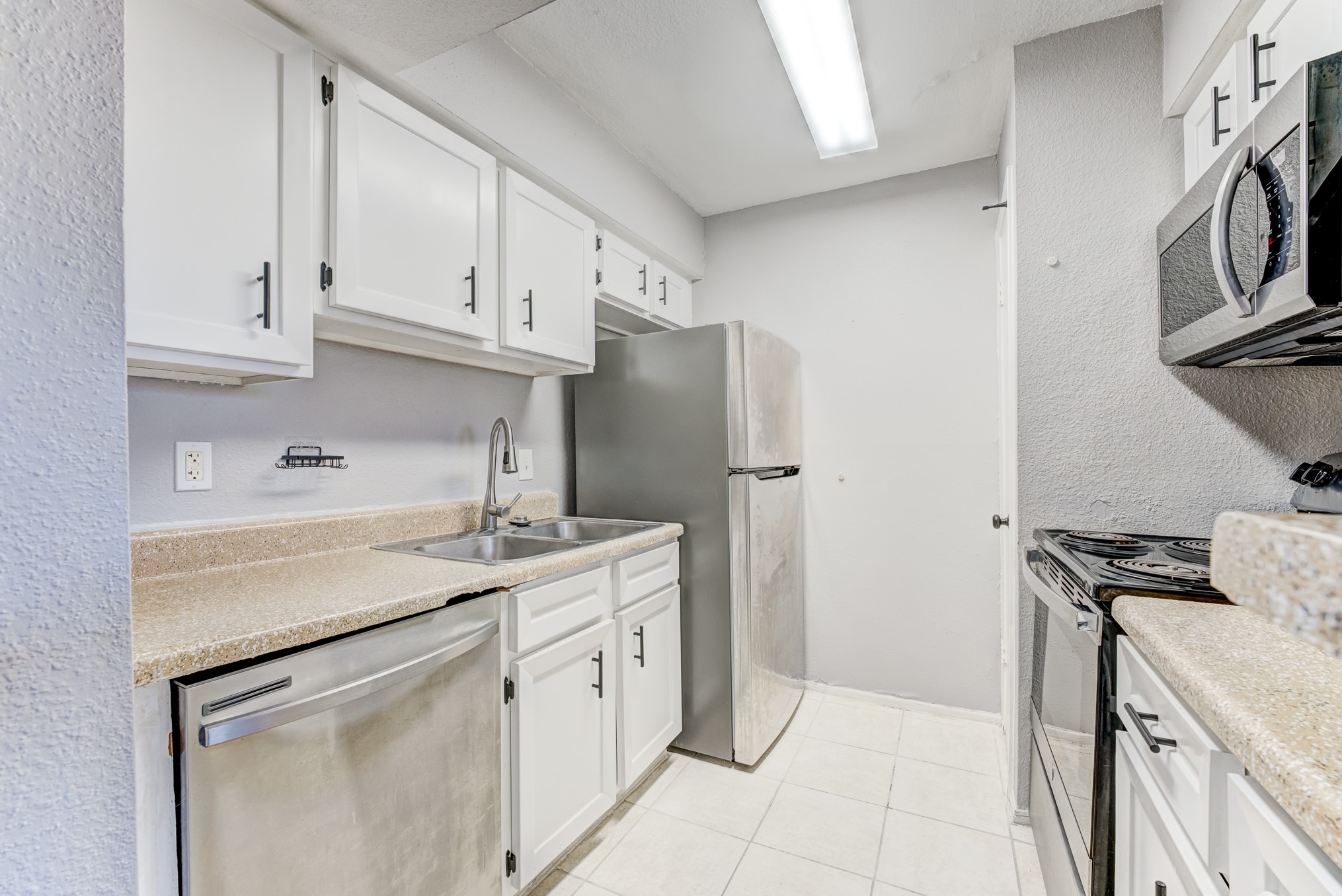 6001 Reims Road, Unit 1101 Houston, TX 77036 - Photo 22 of 35 a kitchen with stainless steel appliances granite countertop a sink stove and refrigerator