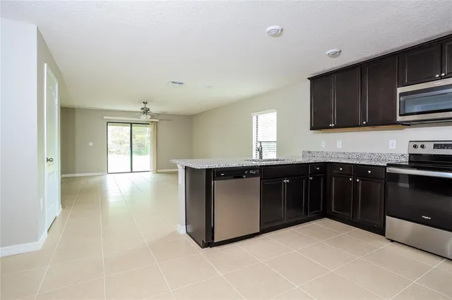 a kitchen with stainless steel appliances kitchen island granite countertop a stove a sink and a microwave