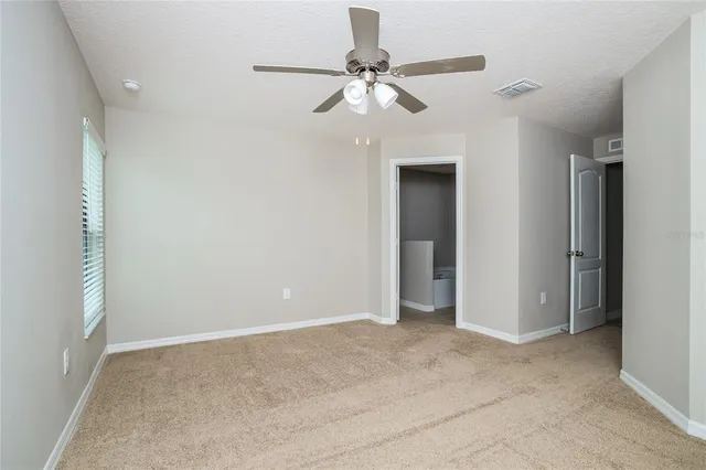 a view of an empty room with a ceiling fan