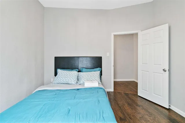 a view of a bedroom with wooden floor and bed