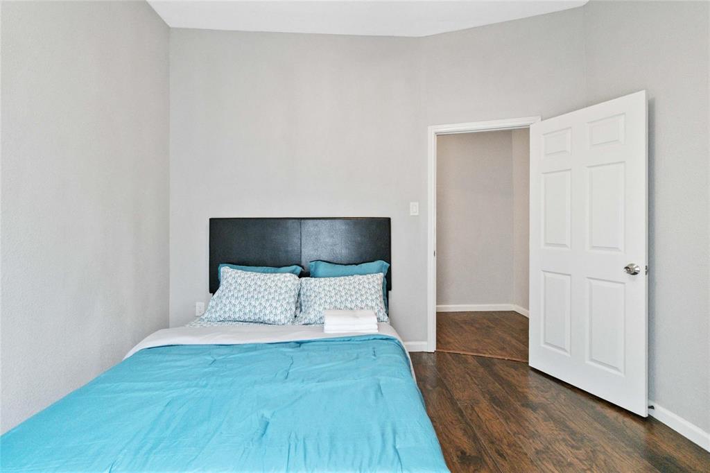 5524 Junius Street Dallas, TX 75214 - Photo 12 of 22 a view of a bedroom with wooden floor and bed
