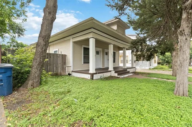 a view of a house with backyard and a tree