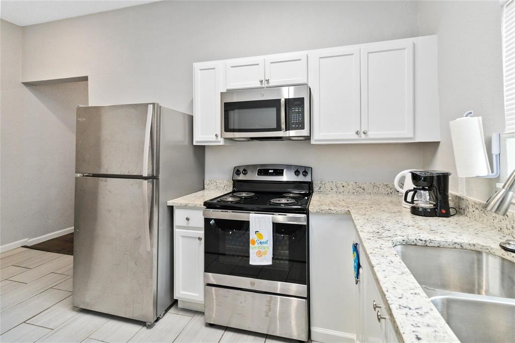 5524 Junius Street Dallas, TX 75214 - Photo 8 of 22 a kitchen with granite countertop a refrigerator stove and sink