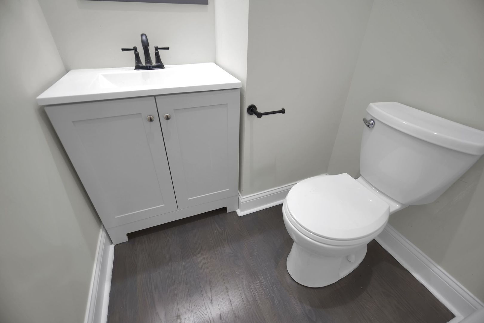 5219 West Monroe Street Chicago, IL 60644 - Photo 11 of 23 a white toilet sitting next to a bathroom sink
