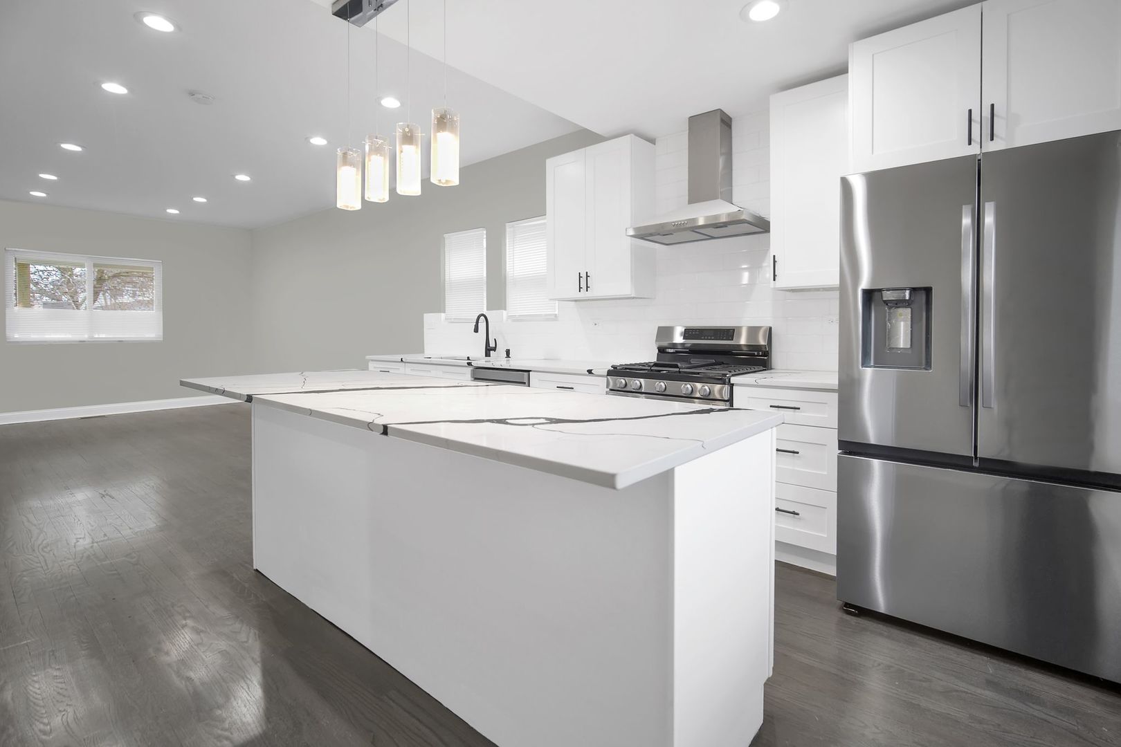 5219 West Monroe Street Chicago, IL 60644 - Photo 3 of 23 a kitchen with stainless steel appliances a refrigerator a sink a stove a microwave a center island and cabinets