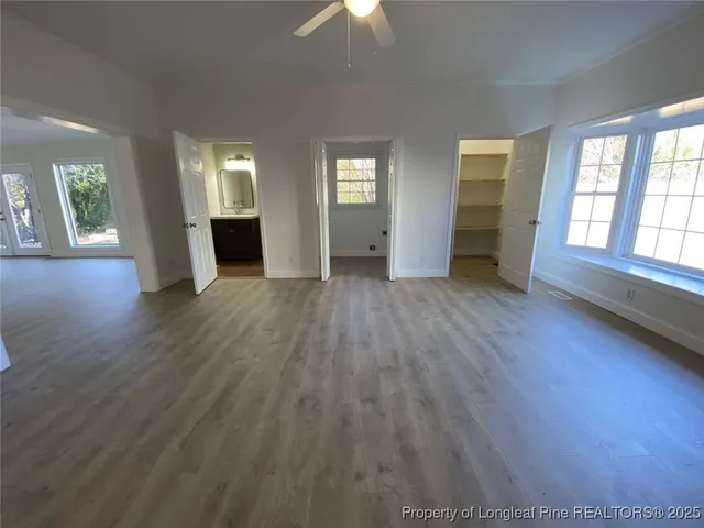 an empty room with wooden floor cabinet and a window