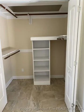 a view of walk in closet with empty racks