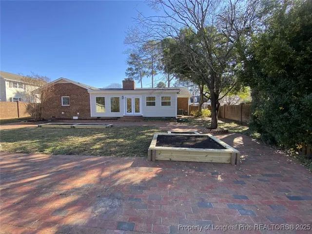 a view of a house with backyard and sitting area