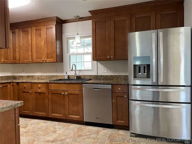 a kitchen with stainless steel appliances granite countertop a refrigerator sink and cabinets