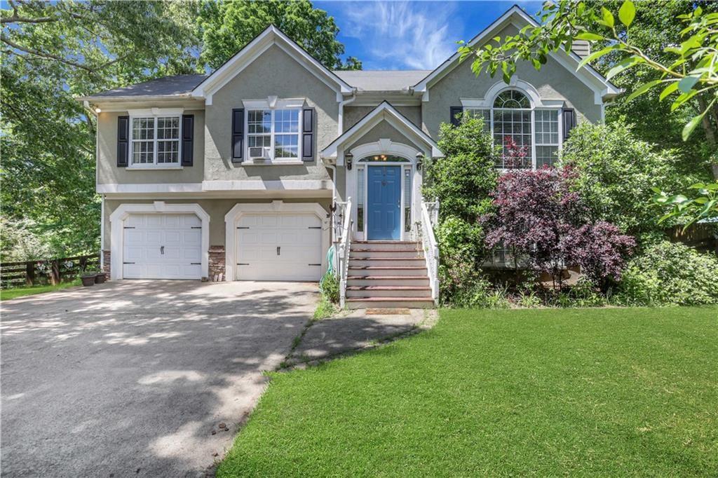 3820 Pheasant Run Trace Cumming, GA 30028 - Photo 1 of 16 a front view of a house with a garden and trees
