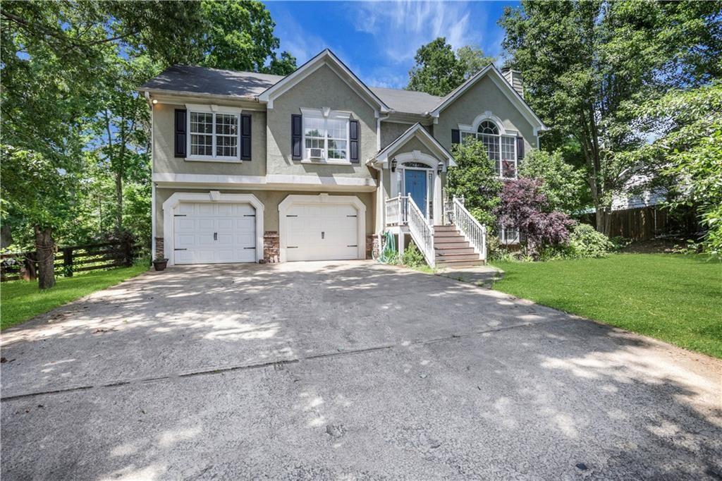 3820 Pheasant Run Trace Cumming, GA 30028 - Photo 5 of 16 a front view of a house with a yard and garage