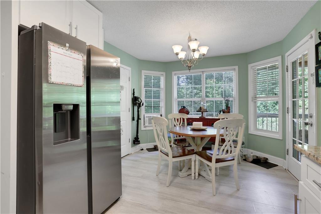 3820 Pheasant Run Trace Cumming, GA 30028 - Photo 7 of 16 a view of a dining room with furniture a livingroom and chandelier