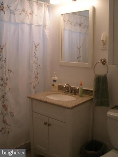 6609 Custer Street Springfield, VA 22150 - Photo 2 of 9 a bathroom with a granite countertop sink and a mirror