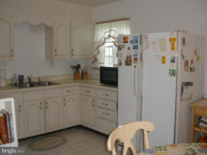 6609 Custer Street Springfield, VA 22150 - Photo 9 of 9 a kitchen with stainless steel appliances granite countertop a refrigerator and a stove top oven