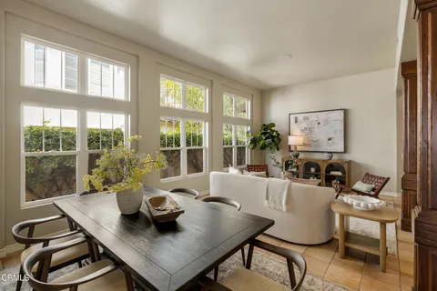 a dining room with furniture a rug and a large window