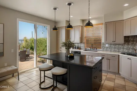 a kitchen with stainless steel appliances granite countertop a sink a kitchen island a counter top space and living room view