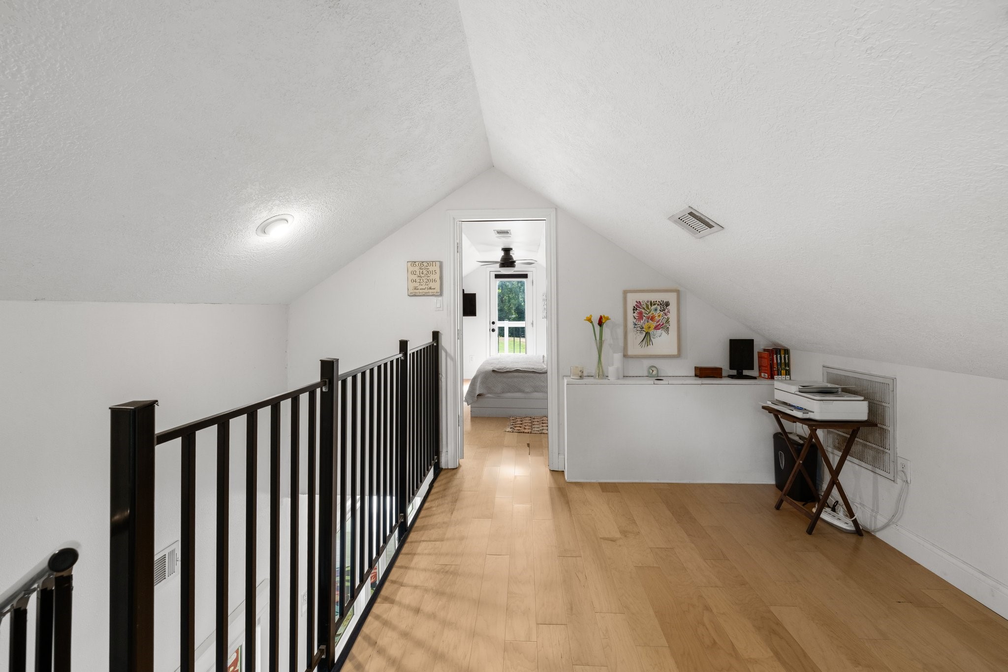 34310 High Point Drive Magnolia, TX 77355 - Photo 31 of 48 This photo showcases a loft with a sloped ceiling and wonterful flooring. It features a small railing, built-in shelf space, and leads to a cozy bedroom, creating a charming and functional upper-level space.