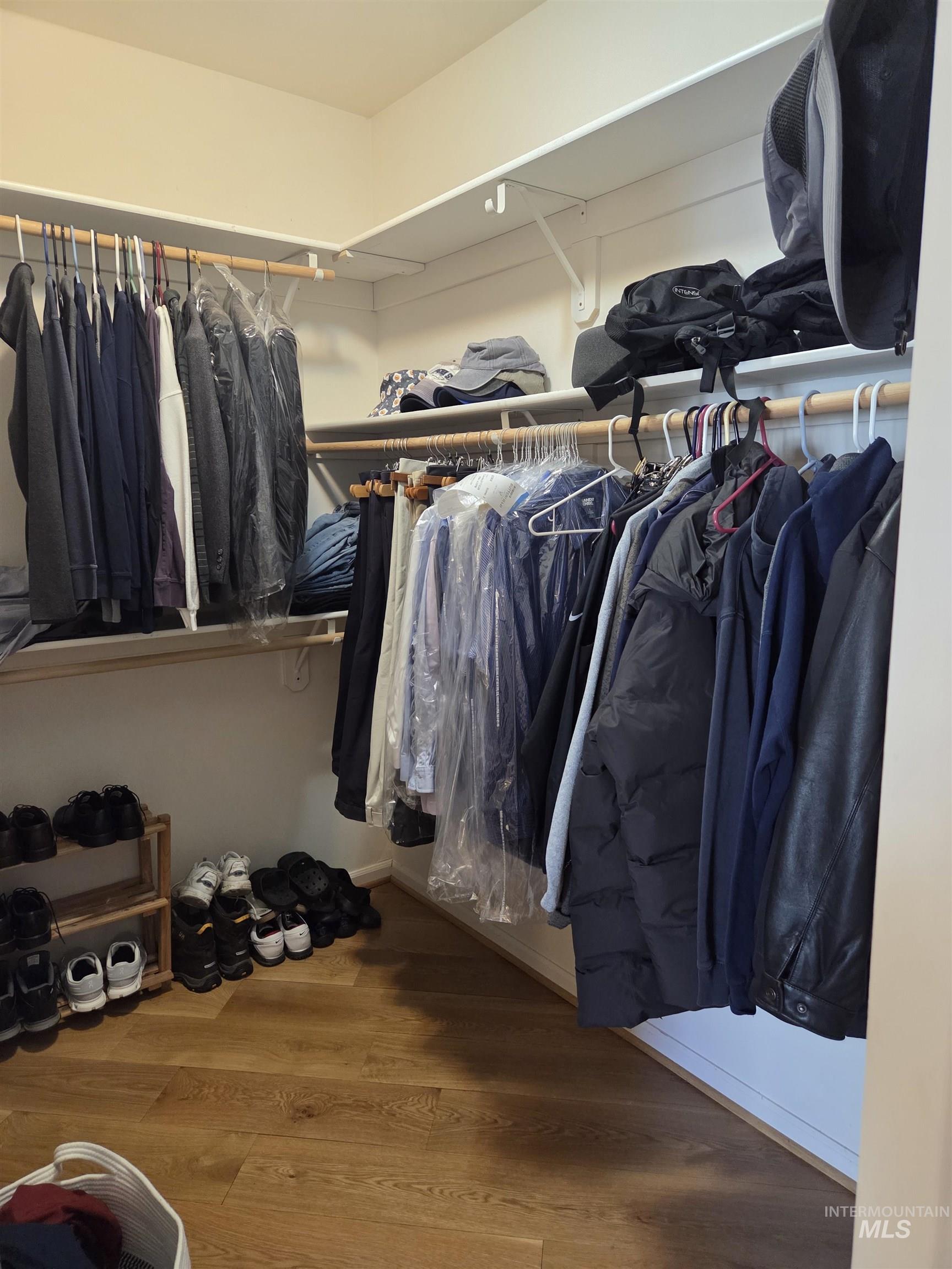 1085 Wallen Road Moscow, ID 83843 - Photo 24 of 50 Walk-in closet featuring wood-finish flooring, white built-in shelving, and multiple clothing rods