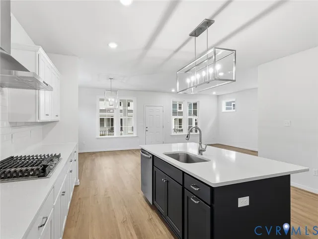 a kitchen with kitchen island a sink appliances and cabinets