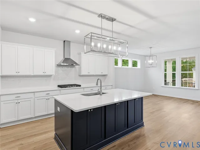a kitchen with a sink a window and wooden floor